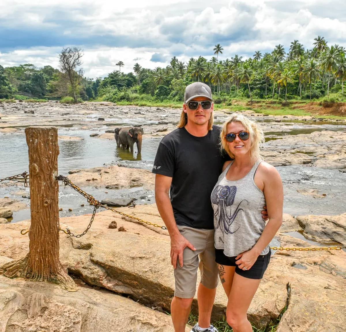 Guests by the river, with an elephant behind them